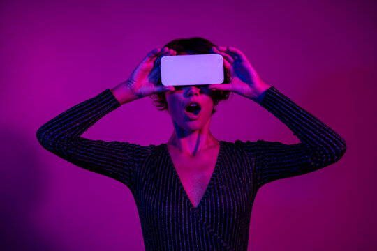 Photo portrait of pretty young girl cover eyes white screen shock wear trendy overall outfit isolated on neon light pink color background