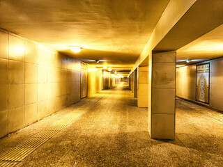 Illuminated Underground Pedestrian Tunnel by Night. A well lit tunnel with columns, leading into...