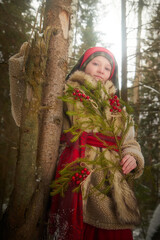 Portrait of Teen girl in thick coat, red sash and branch of fir tree with bright berries in cold...
