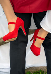 red bridal shoes hooking the groom