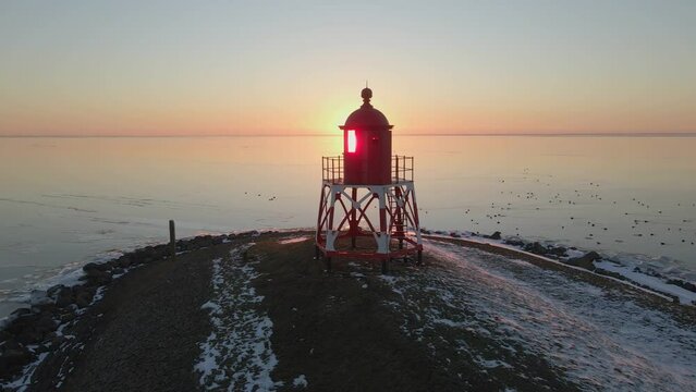 Aerial view of lighthouse at lake during sunset with snow, Stavoren, Netherlands