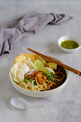 emie, Indonesian noodle with shrimp broth, dry shrimp, , fried onion,onion leaves, bolied potatoes, egg and crackers