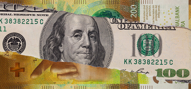 100 US dollar banknote through torn 200 Swiss franc banknote