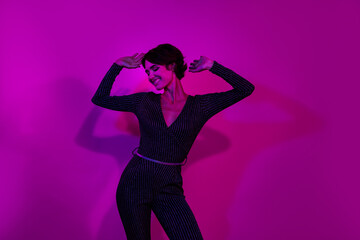 Photo portrait of lovely young lady dance clubber have fun wear trendy overall garment isolated on neon light pink color background