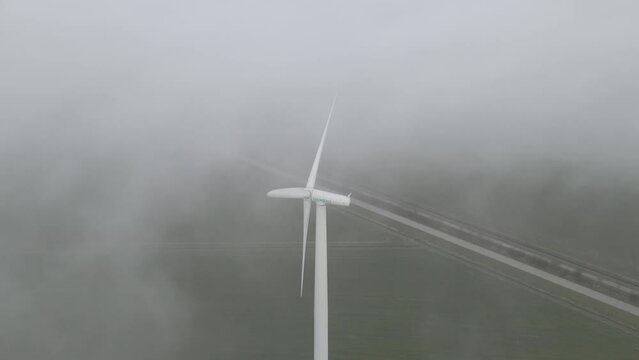 Workum, Netherlands - 22 March 2022: Aerial view of a wind turbine farm in the countryside during foggy sunrise, Netherlands