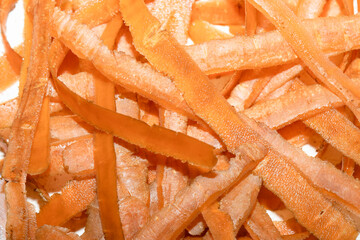 Carrot peelings, the result of cooking in the kitchen.  Entire frame, orange.