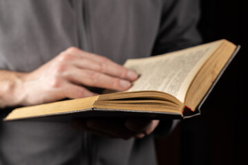 Man reading. Book in his hands. Close up