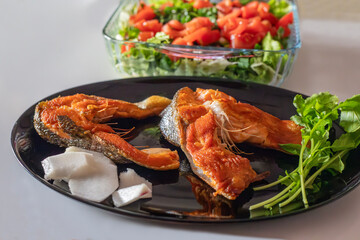 Fried mullet fish, greens and salad