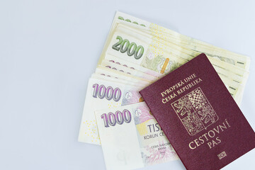 Passport Czech Republic are stacked along with banknotes various denominations of CZK koruna stacked on white background