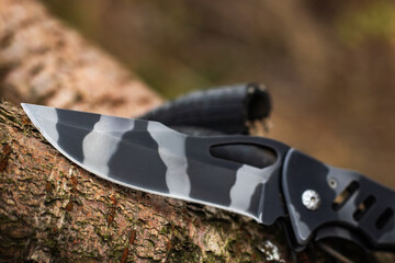 military tactical knife on tree in the forest