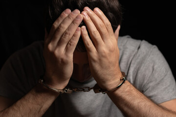 Man, criminal and handcuffs for interrogation, crime or money laundering in arrest on table in room.