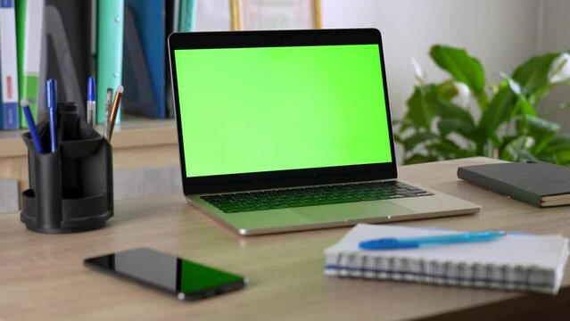 Chroma key green screen laptop computer on desk, close-up