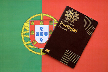 Red Portugal passport of European Union on national flag background close up. Tourism and...