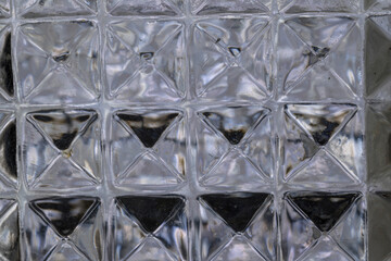 Detail of glass liquor bottle cut square hexagons illuminated horizontally