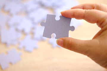 cardboard puzzle piece in female hand, concept puzzle assembly on psychological well-being,...