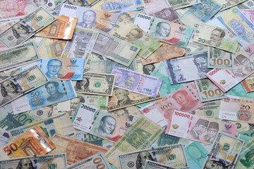 Many banknotes of different currency. Background of big amount of random money bills close up