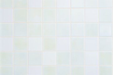 A black and white cat lounges against a clean white tiled wall, creating a striking contrast with its surroundings