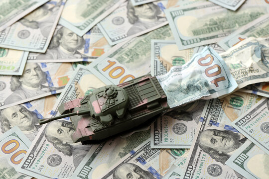 Tank on crumpled hundred dollar bills banknotes. Background of war funding and military support price for United States of America