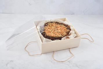 premium freshly baked dark cocoa chocolate brownie gold flower and earl grey peanut round birthday cake with walnut in wood bento box on white marble halal food sweet dessert menu for pastry cafe shop