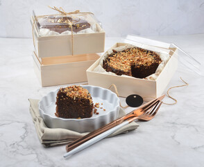 premium freshly baked dark cocoa chocolate brownie gold flower and earl grey peanut round birthday cake with walnut in wood bento box on white marble halal food sweet dessert menu for pastry cafe shop