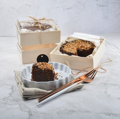 premium freshly baked dark cocoa chocolate brownie gold flower and earl grey peanut round birthday cake with walnut in wood bento box on white marble halal food sweet dessert menu for pastry cafe shop