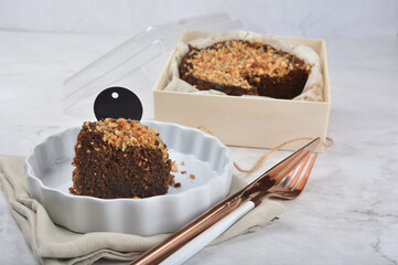 premium freshly baked dark cocoa chocolate brownie gold flower and earl grey peanut round birthday cake with walnut in wood bento box on white marble halal food sweet dessert menu for pastry cafe shop