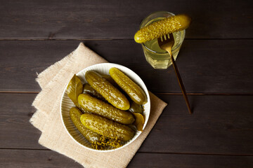 Marinated cucumbers and pickled juice on a dark wooden background. Homemade pickles. Top view.