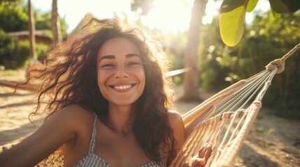 Joyful woman relaxing in a hammock on a sunny beach.