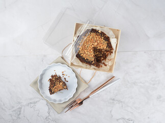 premium freshly baked dark cocoa chocolate brownie gold flower and earl grey peanut round birthday cake with walnut in wood bento box on white marble halal food sweet dessert menu for pastry cafe shop
