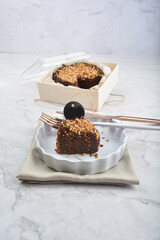 premium freshly baked dark cocoa chocolate brownie gold flower and earl grey peanut round birthday cake with walnut in wood bento box on white marble halal food sweet dessert menu for pastry cafe shop