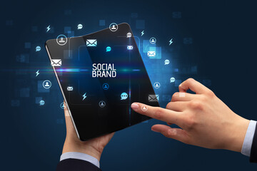 Businessman holding a foldable smartphone, social media concept