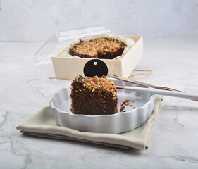 premium freshly baked dark cocoa chocolate brownie gold flower and earl grey peanut round birthday cake with walnut in wood bento box on white marble halal food sweet dessert menu for pastry cafe shop