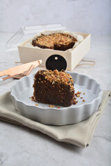 premium freshly baked dark cocoa chocolate brownie gold flower and earl grey peanut round birthday cake with walnut in wood bento box on white marble halal food sweet dessert menu for pastry cafe shop