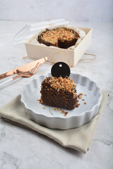 premium freshly baked dark cocoa chocolate brownie gold flower and earl grey peanut round birthday cake with walnut in wood bento box on white marble halal food sweet dessert menu for pastry cafe shop