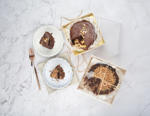 premium freshly baked dark cocoa chocolate brownie gold flower and earl grey peanut round birthday cake with walnut in wood bento box on white marble halal food sweet dessert menu for pastry cafe shop