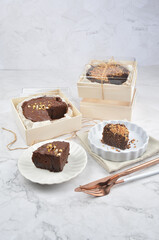 premium freshly baked dark cocoa chocolate brownie gold flower and earl grey peanut round birthday cake with walnut in wood bento box on white marble halal food sweet dessert menu for pastry cafe shop