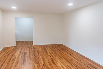 A house for sale with an empty white living room or den of a newly renovated and painted house with...