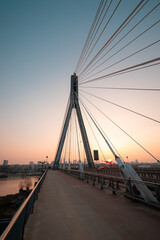 Wide-angle perspective of a suspension bridge at sunset 