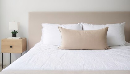 Beige cushion on white bed - obrazy, fototapety, plakaty