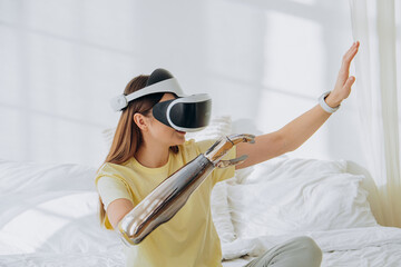 A woman explores virtual reality, wearing a VR headset and interacting with a futuristic robotic...