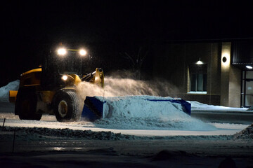 Blue Wheel Loader Box Plow Pushing Freshly Fallen Snow at Night