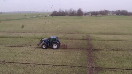 Aerial view of tractor with implement to build ditches in meadow, Netherlands