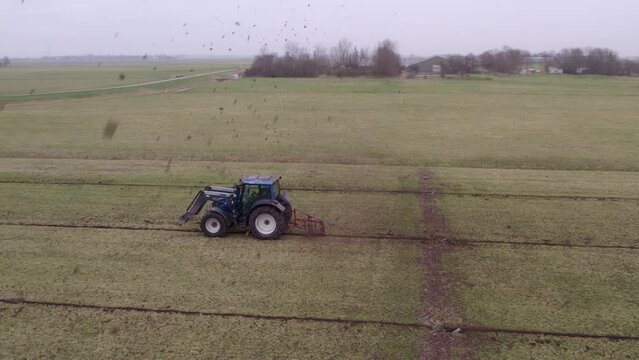 Aerial view of tractor with implement to build ditches in meadow, Netherlands