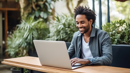 Smiling Businessman Working on Laptop Outdoors on a Sunny Day