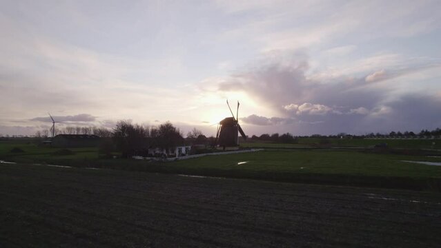 Aerial view of famous spinning Dutch windmill (Nijlannermolen) at sunset, Workum, Netherlands