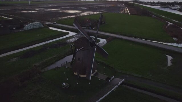 Aerial view of famous spinning Dutch windmill (Nijlannermolen) at sunset, Workum, Netherlands