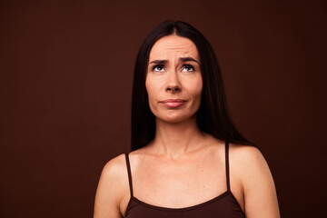 Fototapeta premium Photo portrait no filter of pretty young girl look up skeptical empty space dressed stylish underwear isolated on brown color background
