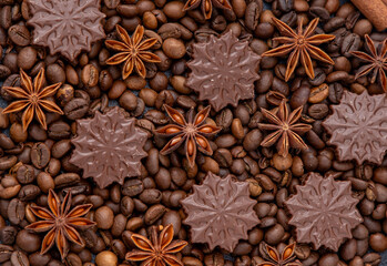 Food background. Coffee beans, anise stars and chocolate candies top view. - obrazy, fototapety, plakaty