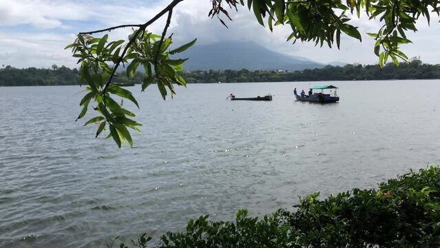 Unrecognizable Fishermen are navigating a small wooden boat on a lake. Blurs, selective focus