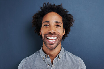 Portrait, smile and black man with fashion, happiness and confident guy on a grey studio...